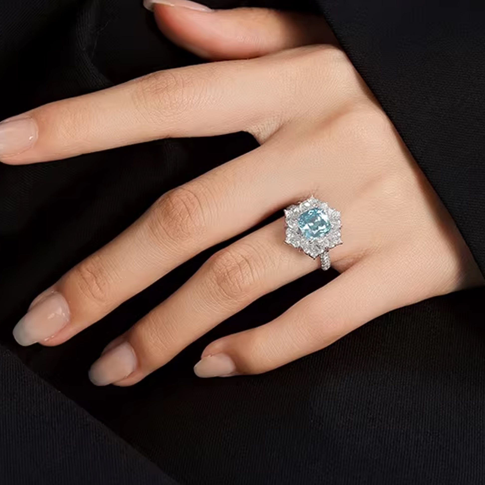 close-up of hand wearing blue cushion cut diamond halo ring