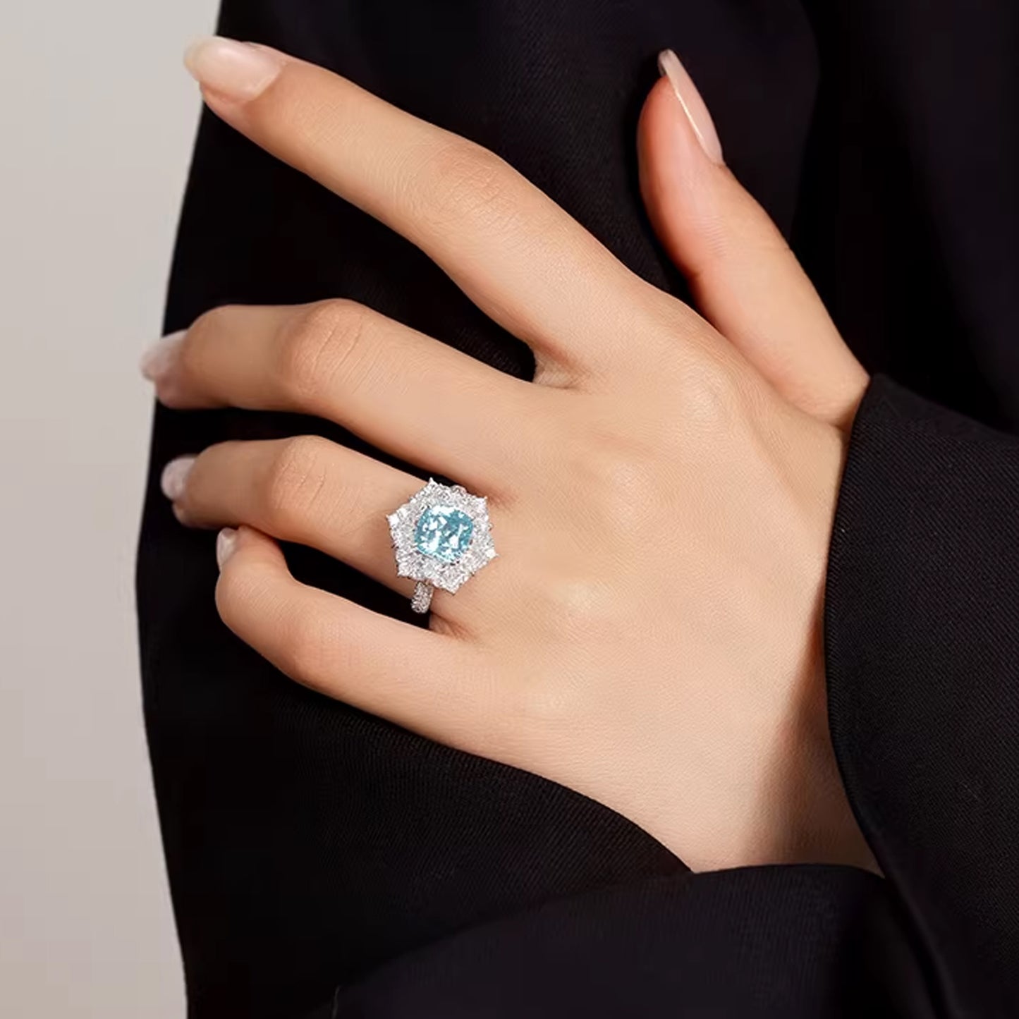 woman wearing cushion cut aquamarine diamond halo ring in platinum
