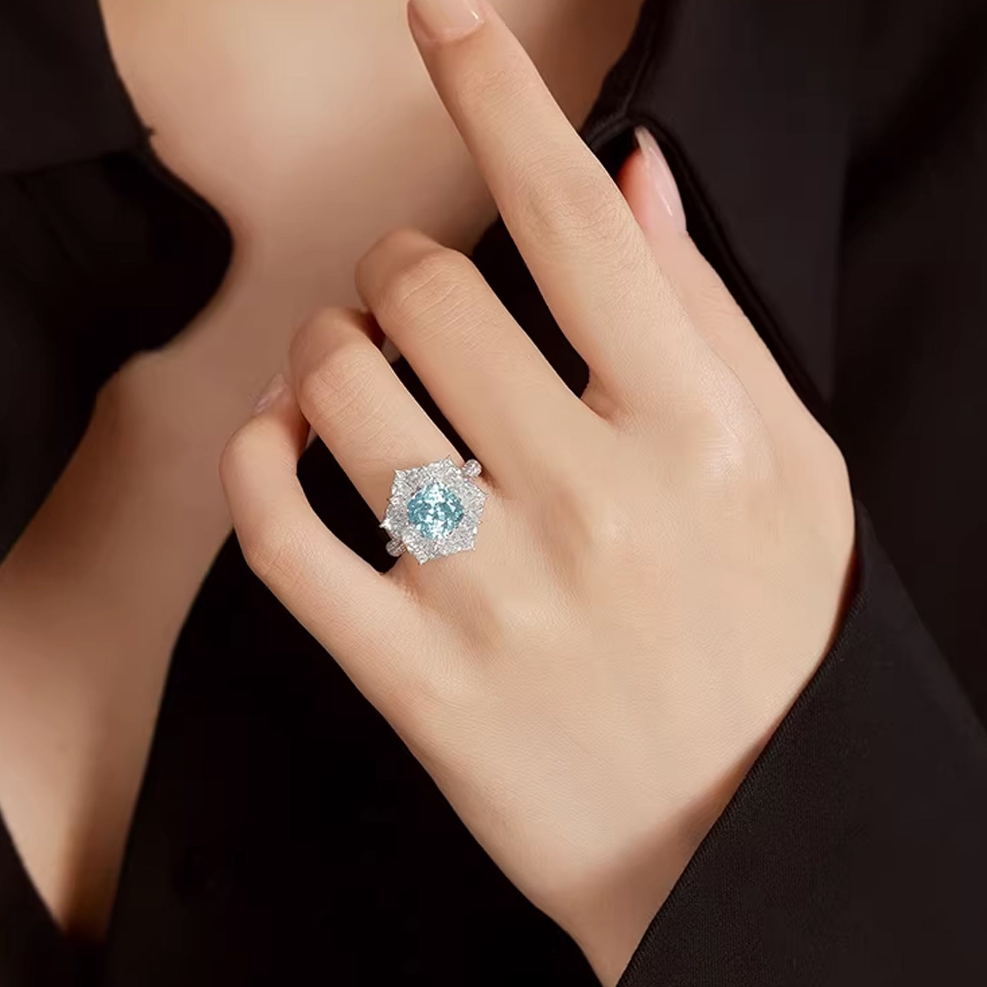 female hand showcasing sparkling aquamarine diamond statement ring